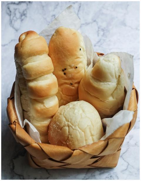 A variety of freshly baked breads in a wooden bask