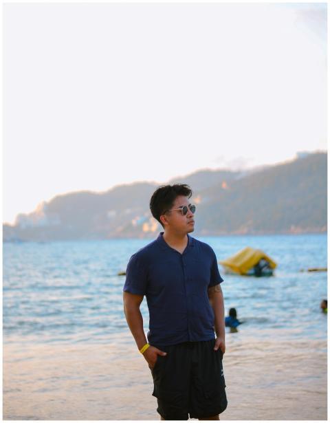 Young man in sunglasses stands on a peaceful beach