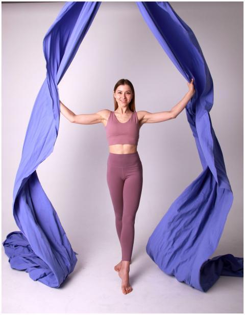A fit woman in lilac activewear posing with vibran