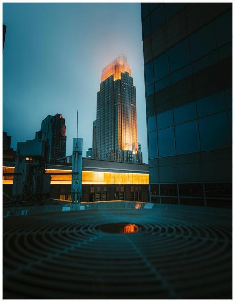 Tall modern skyscraper in a cityscape illuminated