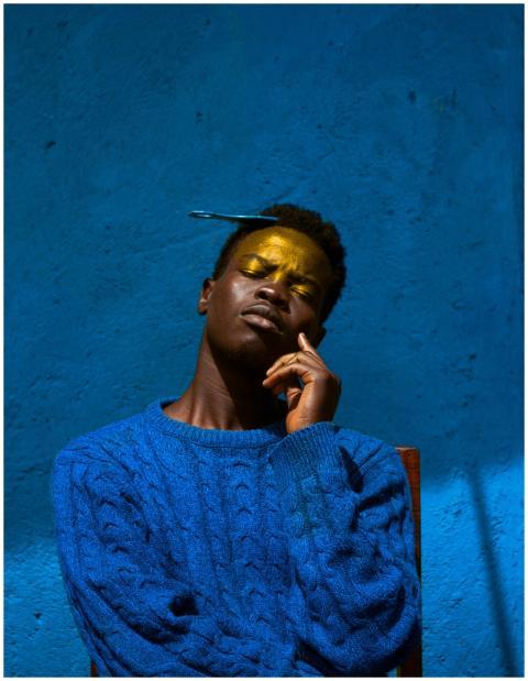 Dramatic portrait of a man against a rich blue bac