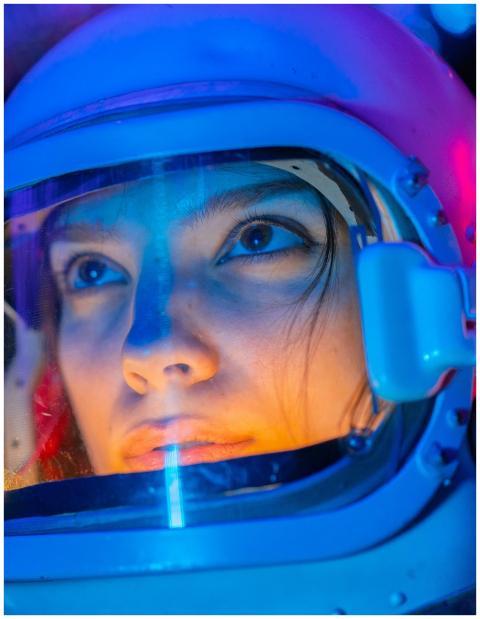 Vivid close-up of a woman in a space suit, reflect