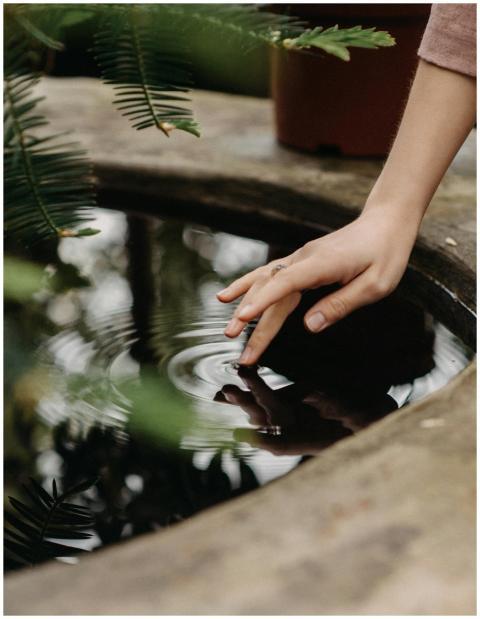 A serene moment of a hand gently touching water, c