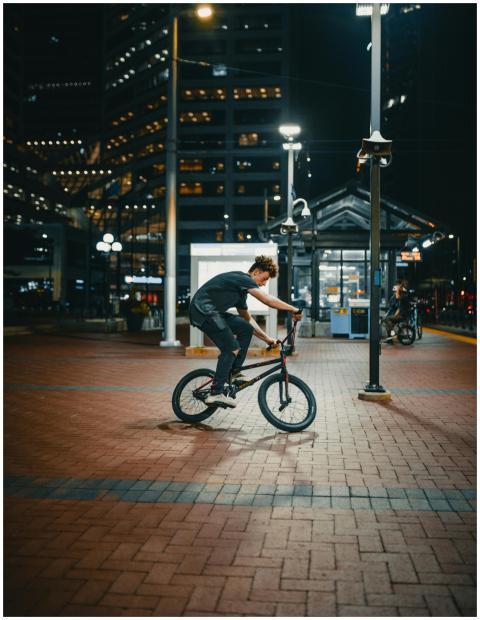 Cyclist performs stunts on a bike under city light
