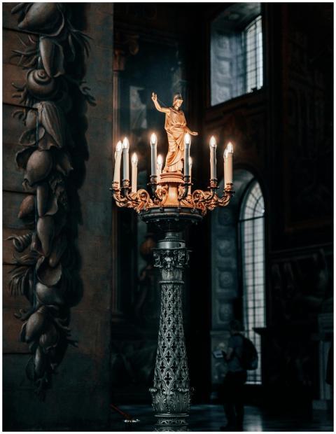A detailed view of a golden statue candlestick in