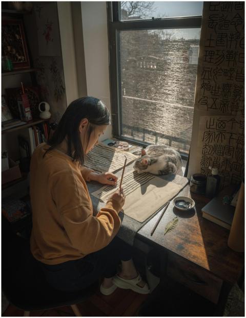 Asian woman practicing calligraphy by a sunny wind