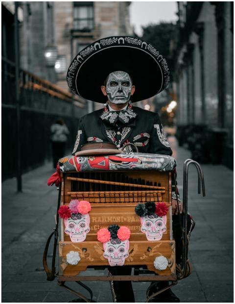 Man with face paint and traditional attire in stre