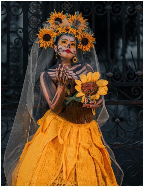 Woman in Dia de los Muertos attire, sunflowers, fa