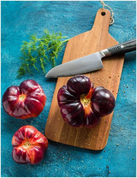 Vibrant heirloom tomatoes with herbs and knife on