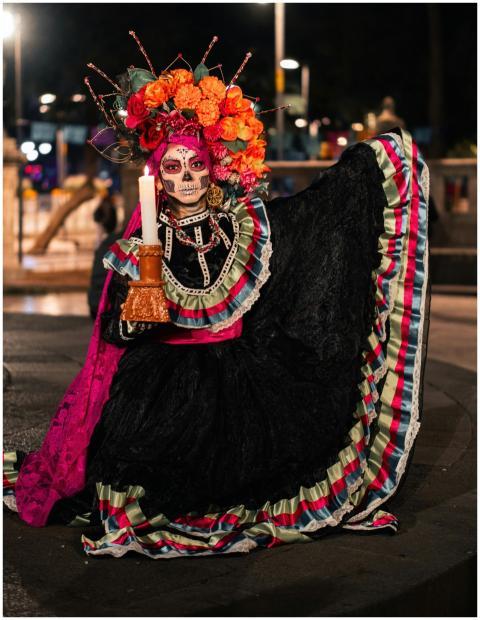 Colorful Day of the Dead costume with candle in ni