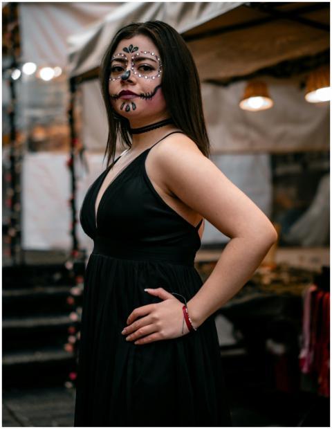 Woman wearing artistic face paint and black dress