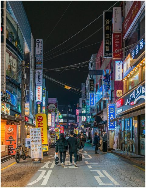 Colorful neon lights illuminate a bustling street