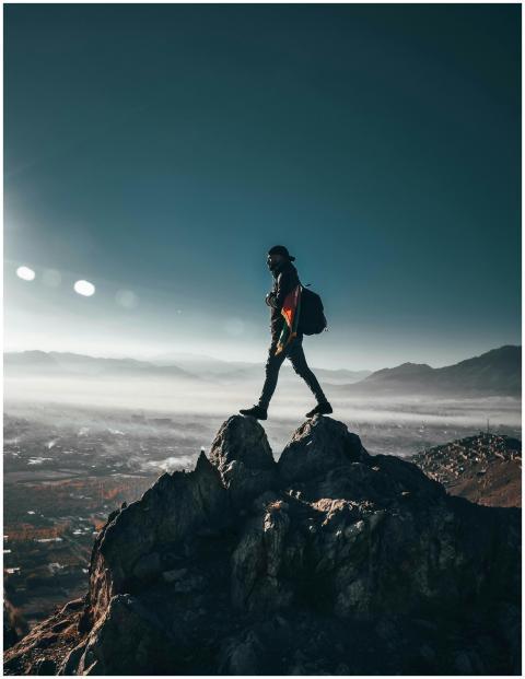 A lone hiker conquering rocky peaks in Nawur, Afgh