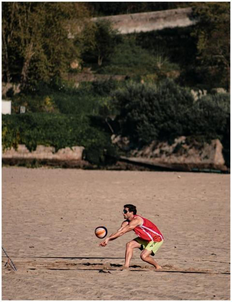 A man playing beach volleyball on a sandy outdoor