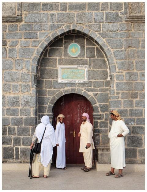 Four people outside Abu Bakr Mosque in Medina, Sau