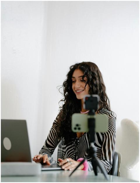 Smiling woman using laptop and smartphone for remo