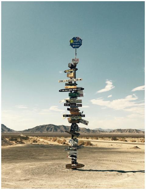 Tall signpost in a desert landscape under a clear