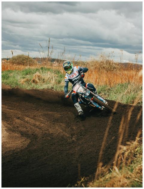 Exciting motocross rider cornering on dirt track o