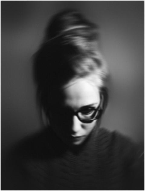Grayscale portrait of a woman with glasses, exhibi