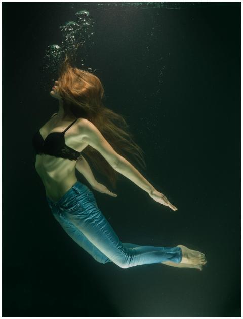 A captivating underwater photo of a woman in jeans