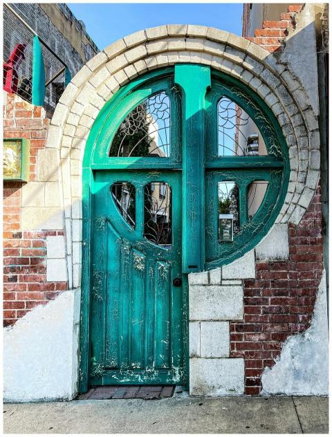 Decorative turquoise door in a brick archway, Waco