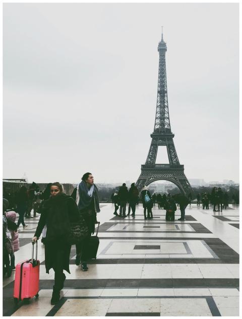 Crowds of tourists with luggage at the Eiffel Towe