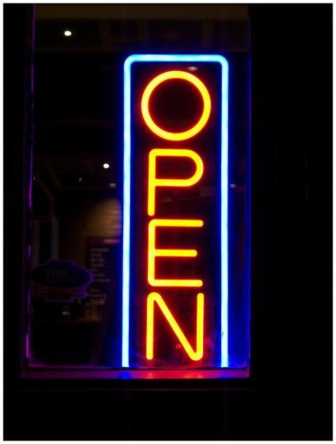 Illuminated neon sign displaying 'OPEN' with vibra