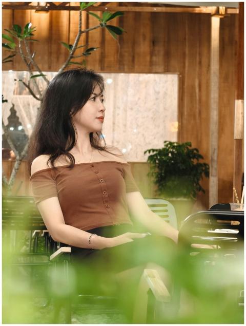 Woman sitting in stylish indoor setting with plant