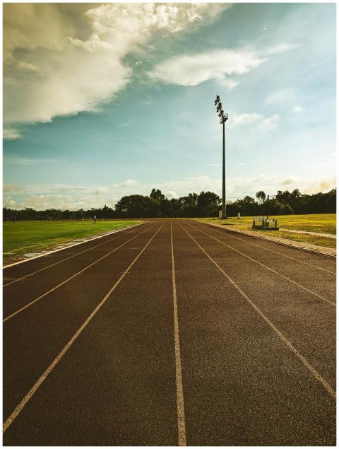 A vibrant outdoor running track on a sunny day, pe