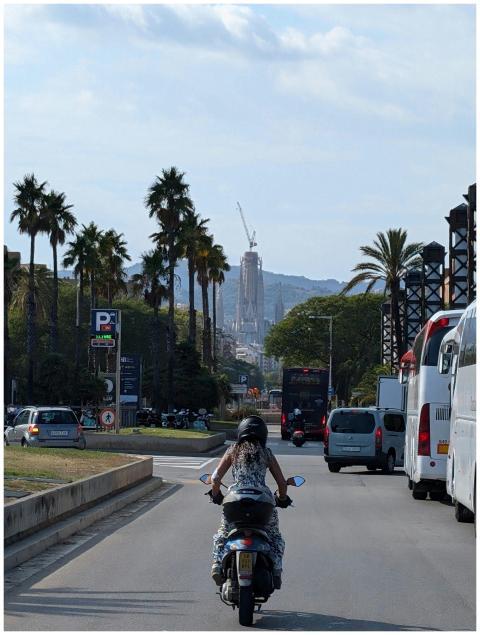 Motorcyclist on a city street with Sagrada Familia
