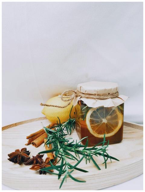 Artistic arrangement of lemon, herbs, and honey ja