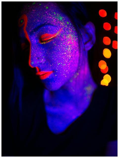 Artistic portrait of a person with neon face paint