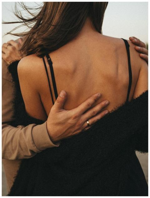 A close-up back view of a couple embracing, convey