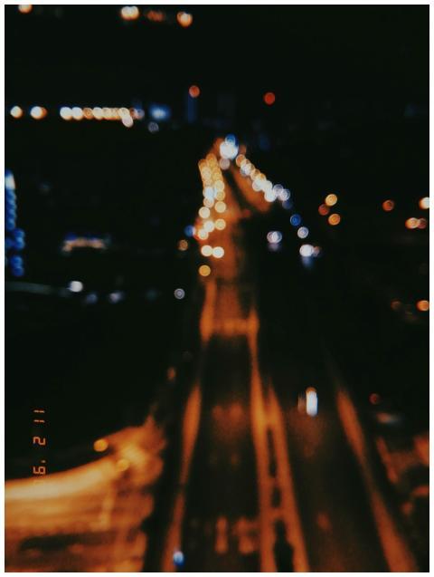 Blurred nighttime view of a road and city lights i