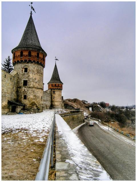 Historic castle towers overlooking snow-dusted lan