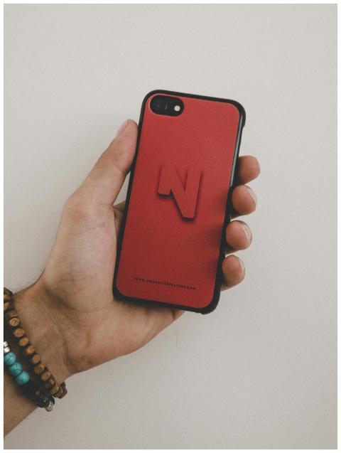 A hand holding a smartphone with a distinct red ca