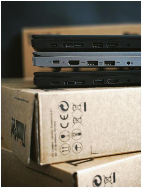 Close-up of stacked modern laptops on cardboard bo