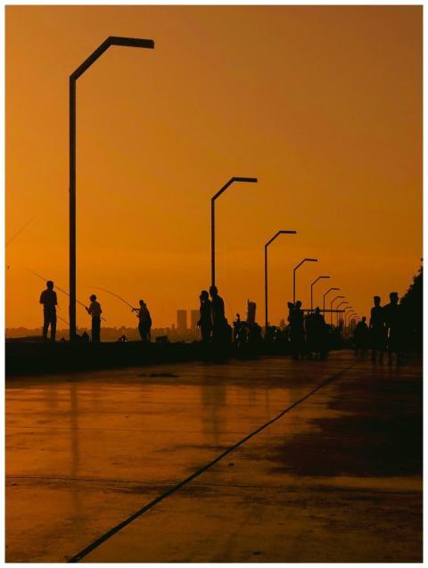 People silhouetted against a vibrant sunset sky by