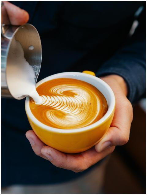 From above of crop anonymous male pouring cream in