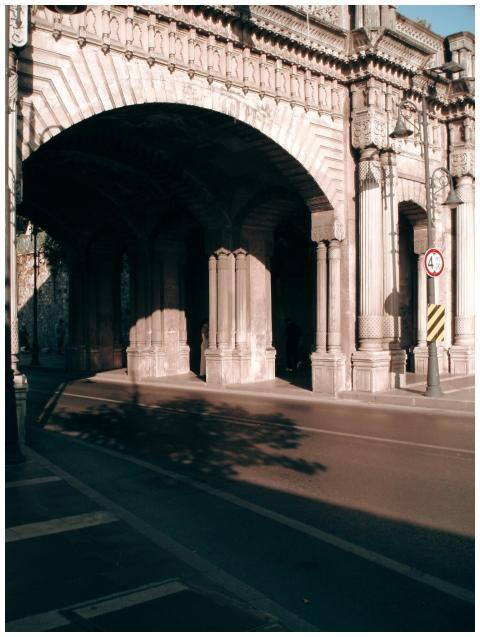 A classic stone archway casting shadows over an em