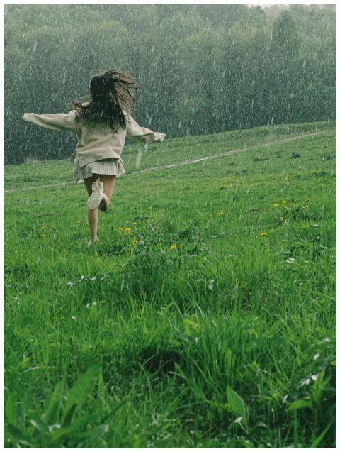 A person runs through a vibrant green field during
