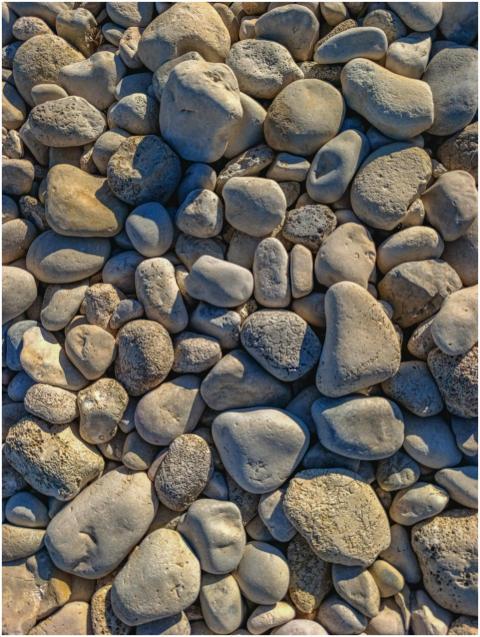 Smooth pebble stones on a sunny beach in El Campel