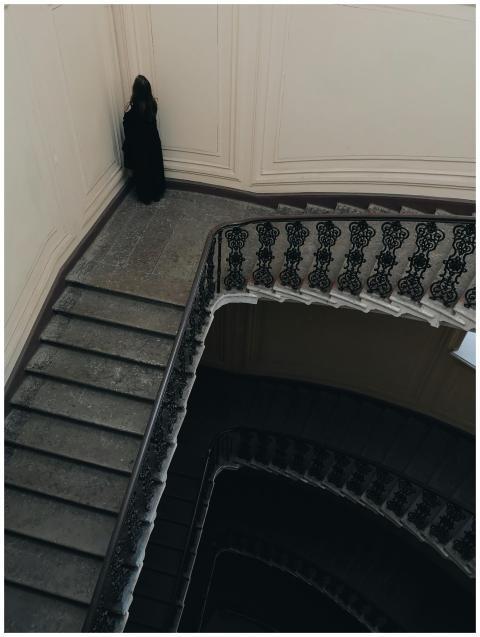 Moody shot of a spiral staircase and person in a h