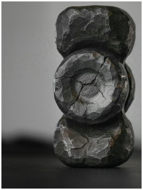 Detailed view of a textured black stone sculpture