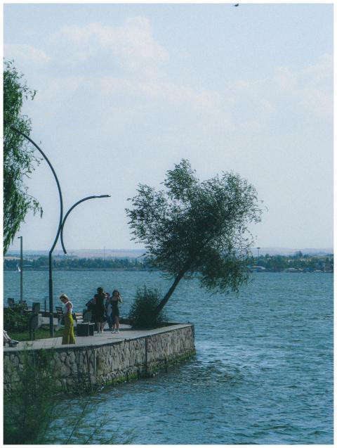 A tranquil lakeside scene with people walking alon