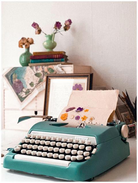 Vintage typewriter with flowers, books, and decor
