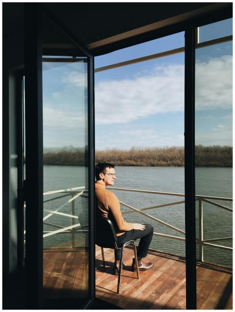 A man enjoys a peaceful moment on a balcony overlo