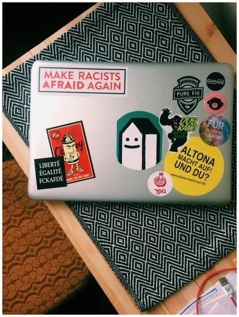 Laptop covered in colorful stickers with political