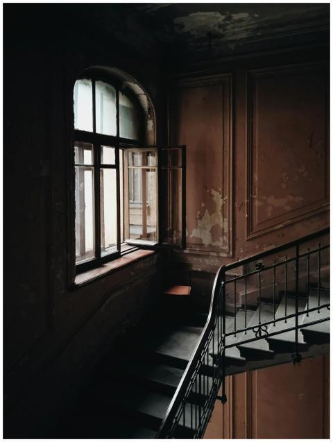 Dimly lit abandoned stairwell with vintage archite