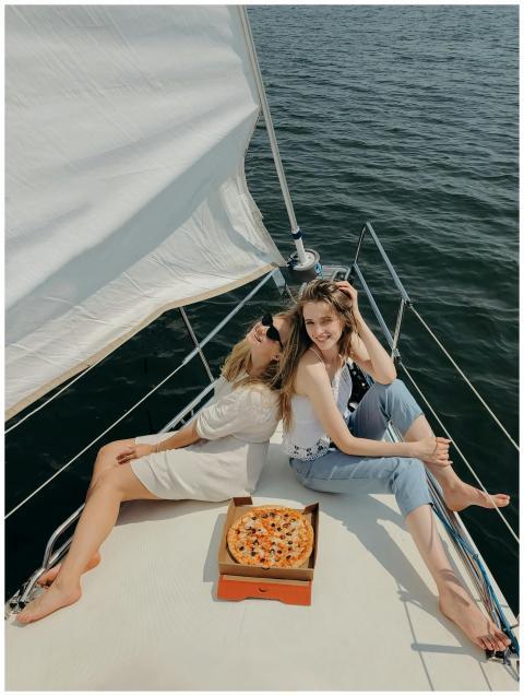 Two young women enjoying a sunny day on a yacht wi